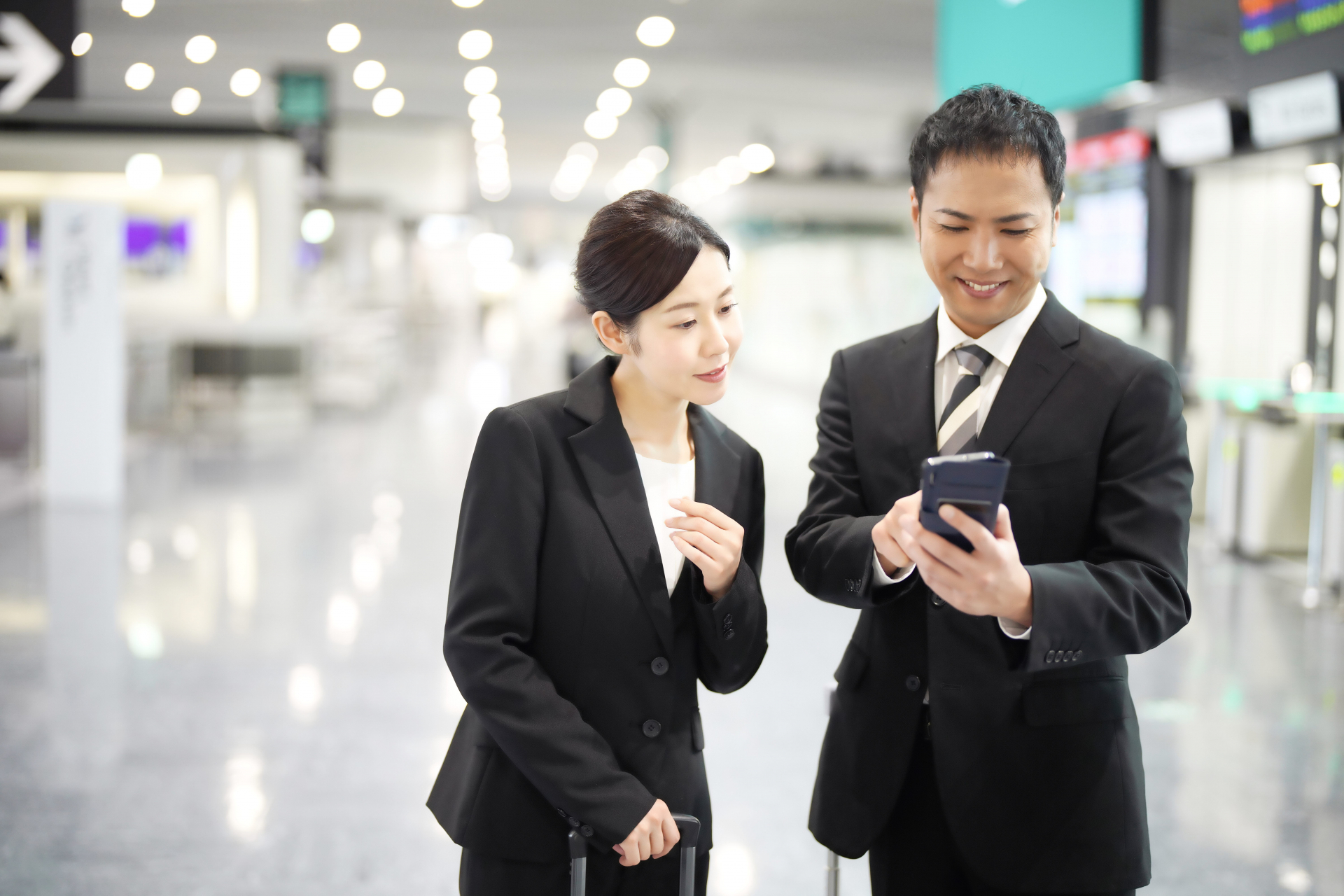 男性のスマホをのぞき込む女性