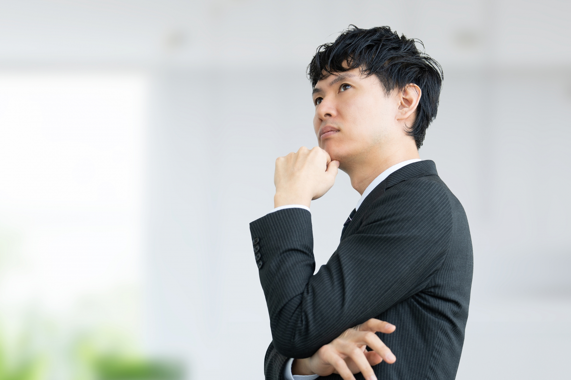 考えごとをする男性ビジネスマン