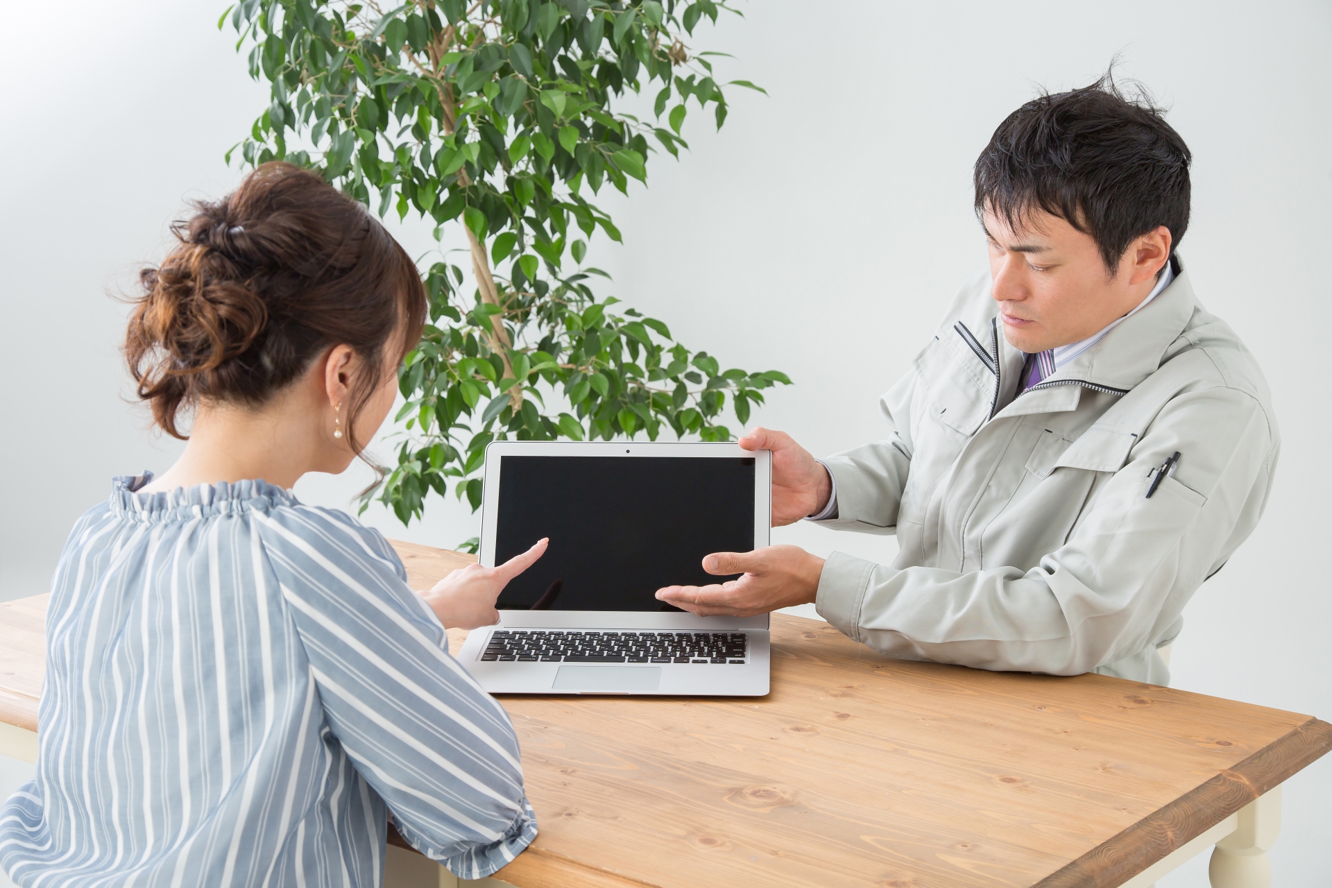 打ち合わせする作業着の男性