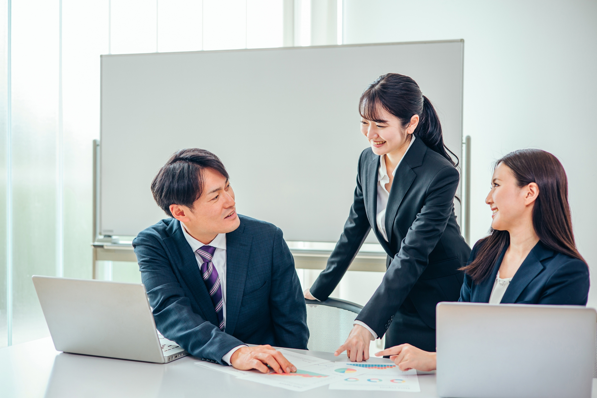 会議で改善点を話し合う会社員の男女