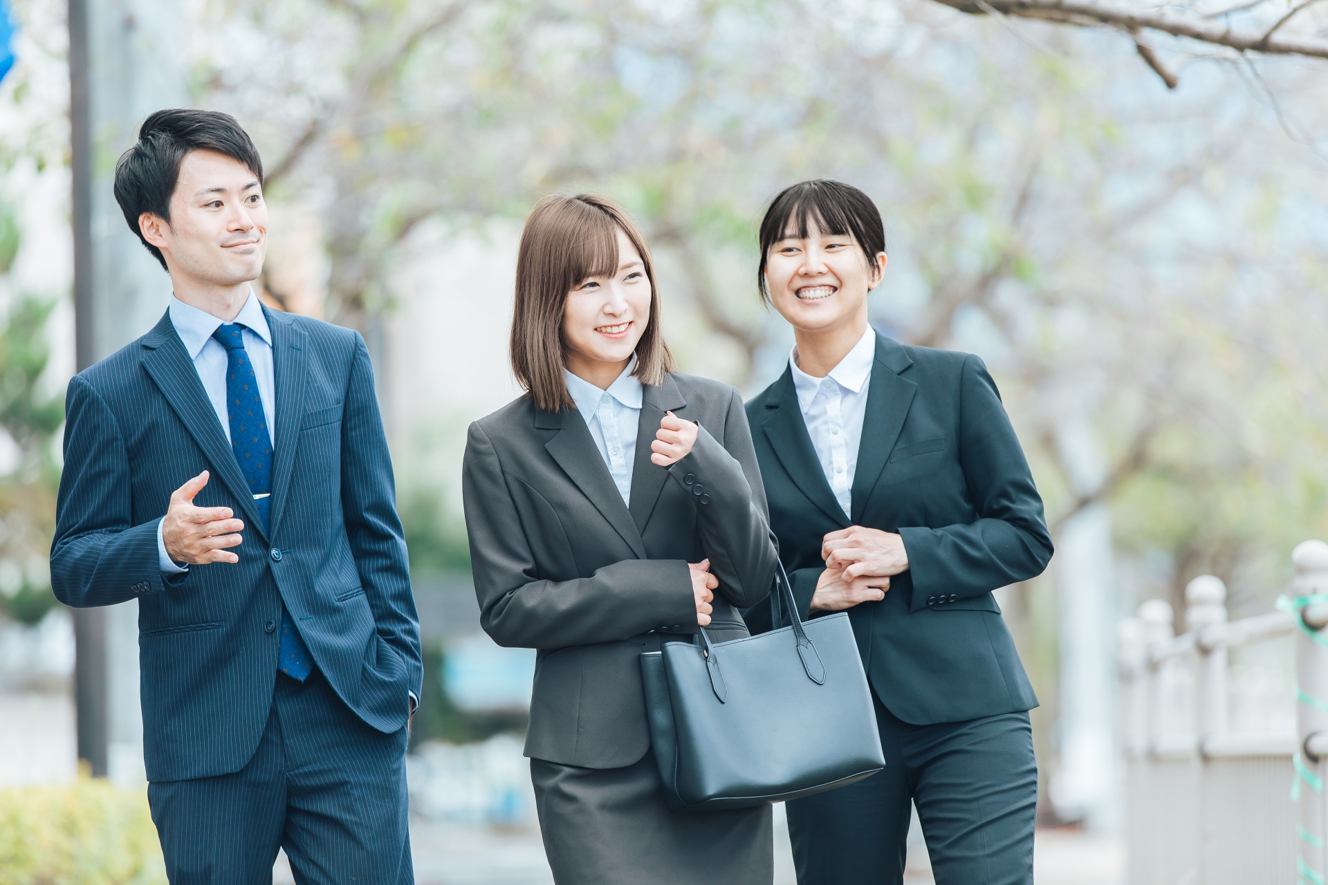 外を歩くスーツの男女