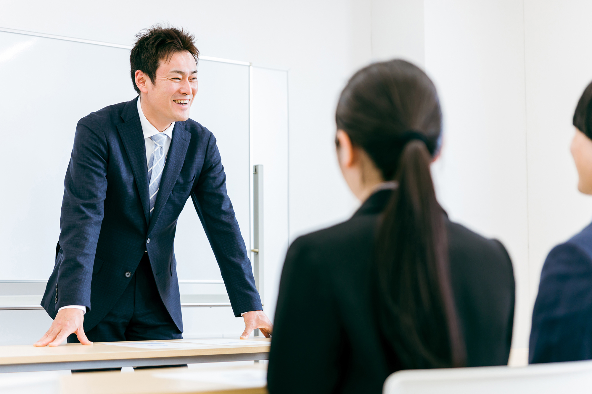 セミナーをする笑顔のスーツ姿の先生