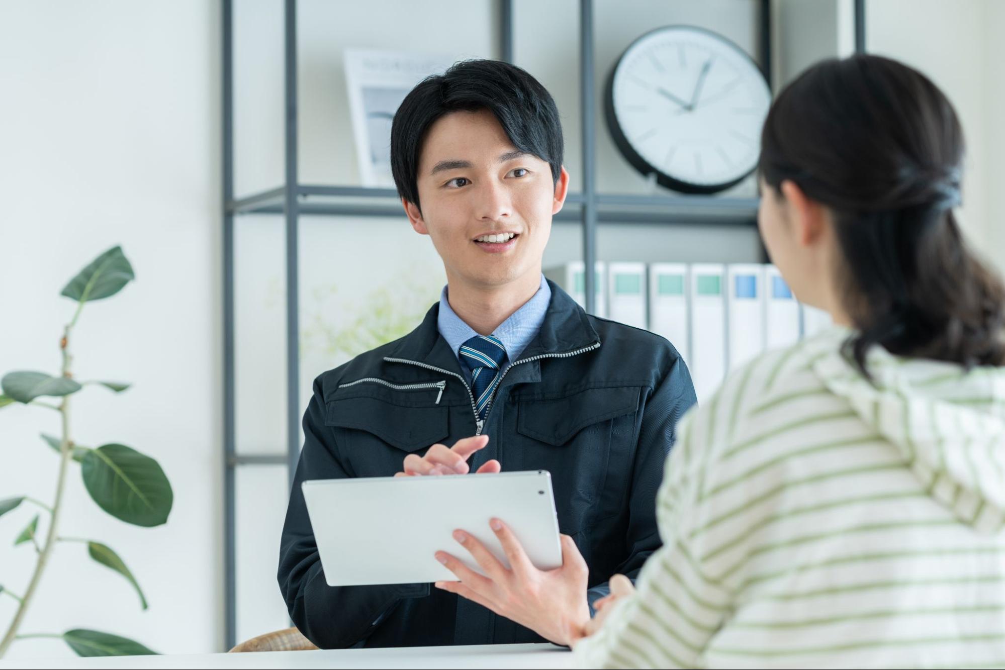 若い女性に営業する作業員