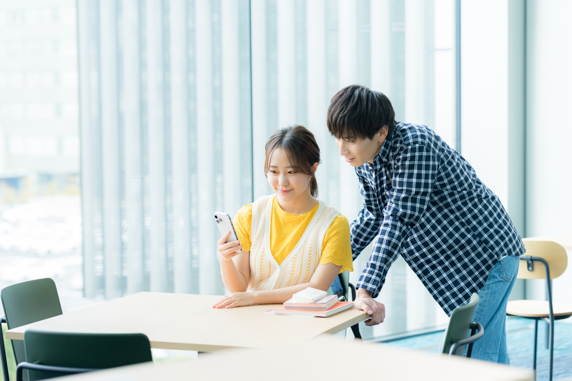 スマホを見ながら話す学生たち