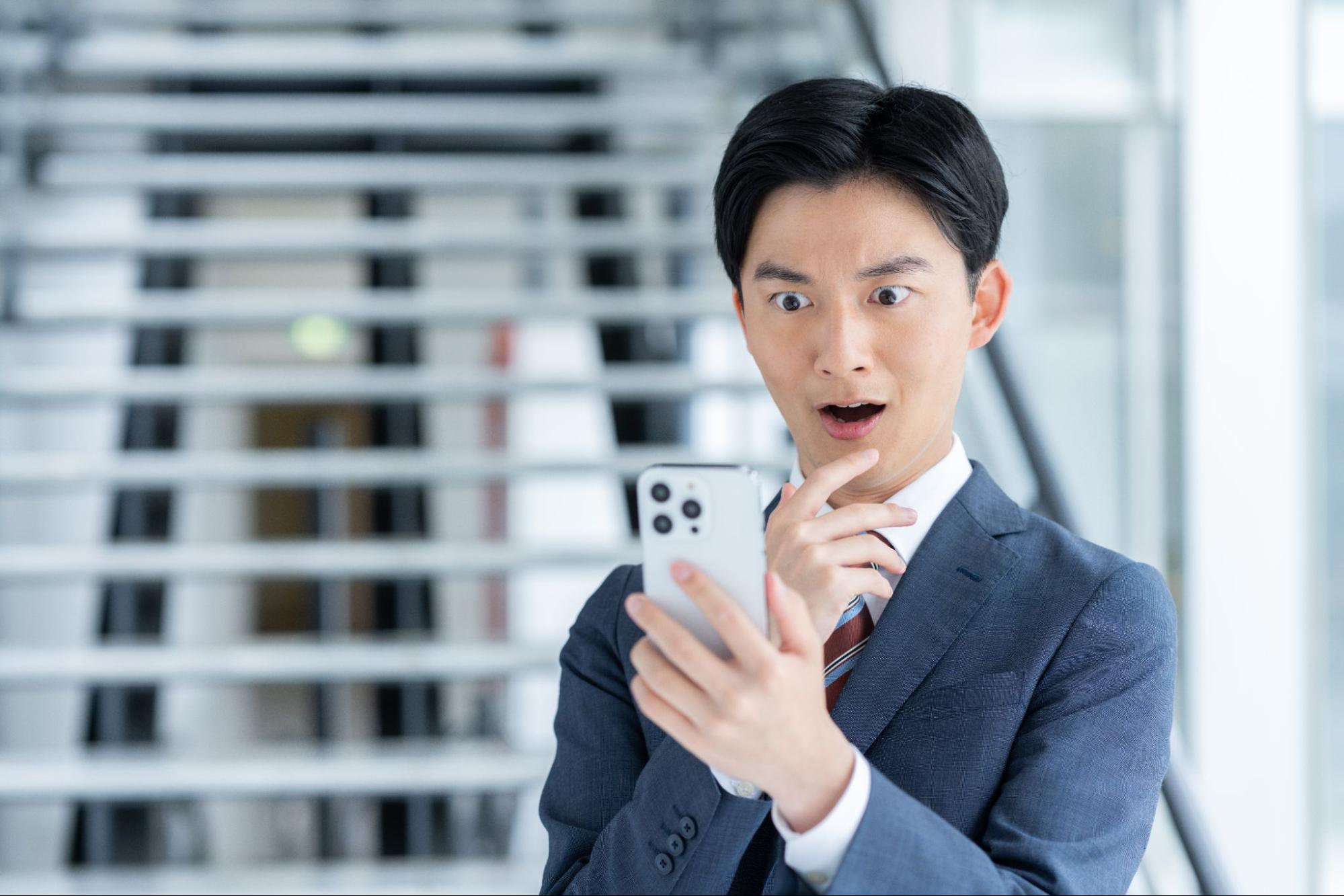 スマホを見て驚く男性