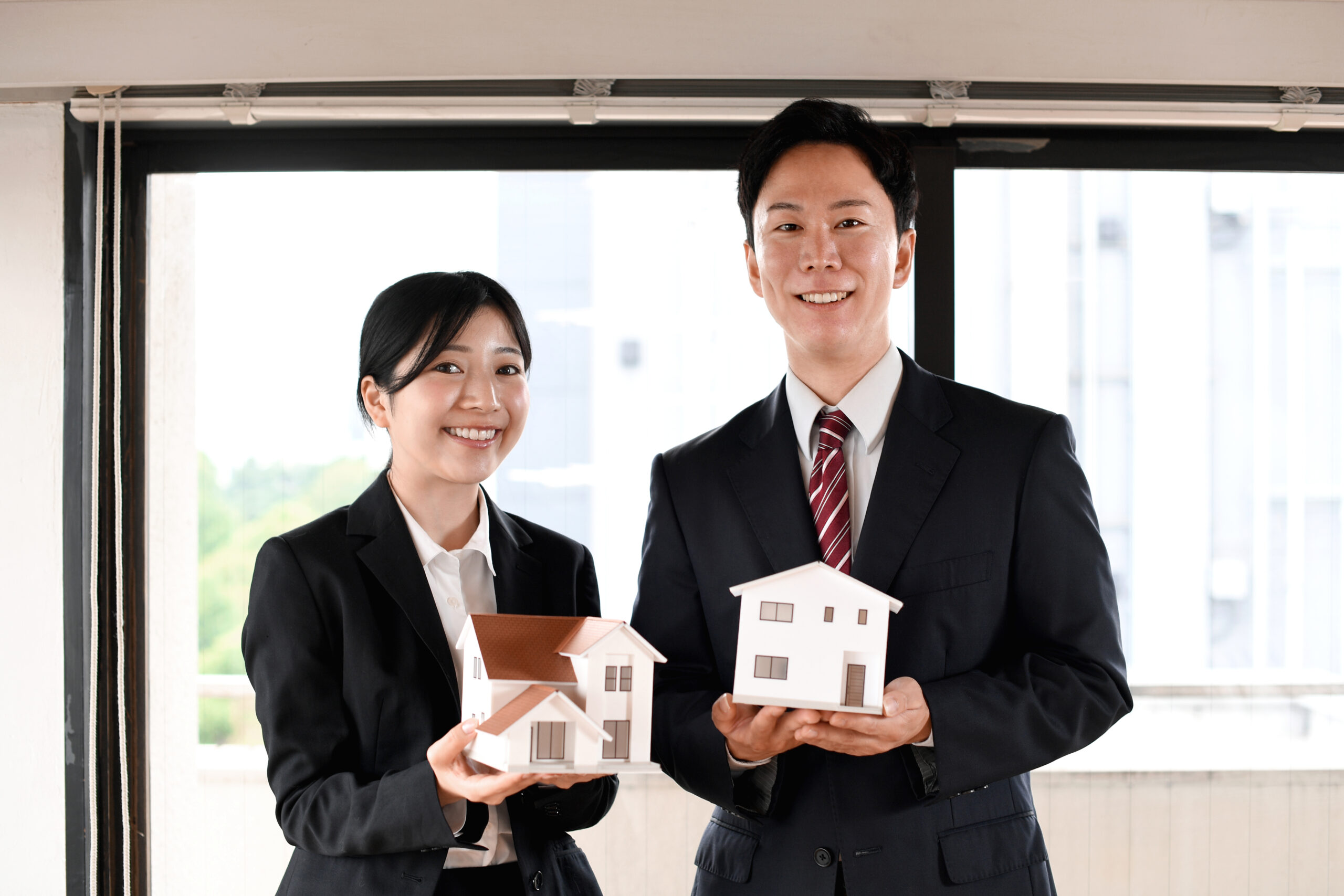 住宅模型を持つビジネスマン