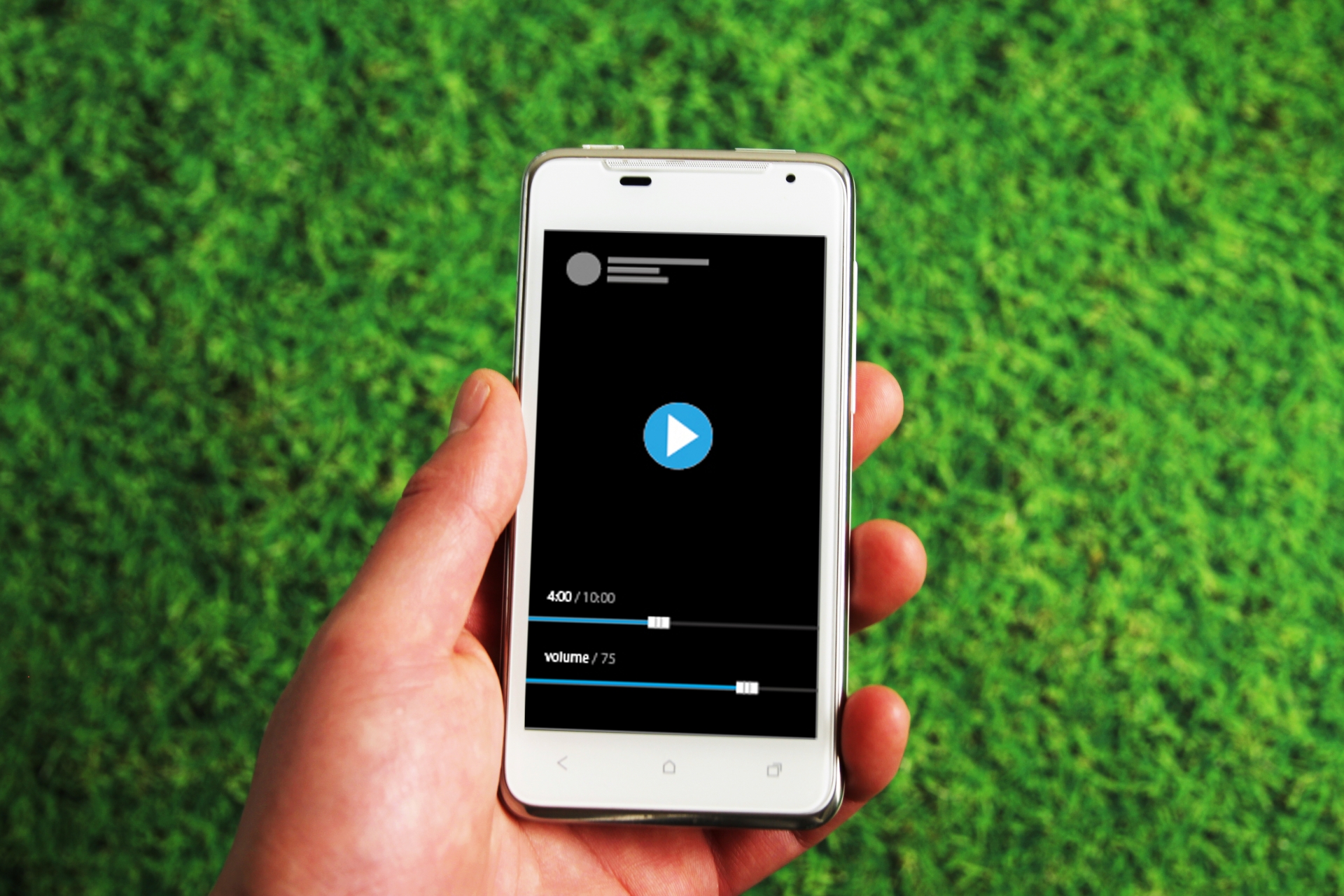 芝生を背景にスマホを持って配信された動画と音楽を楽しもうとする