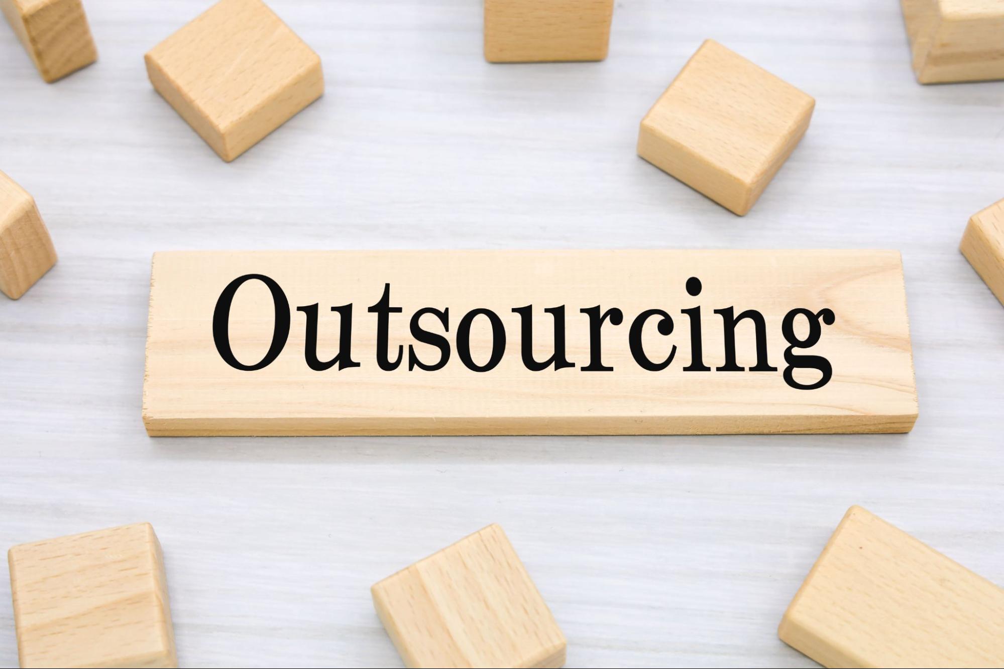 qutsourcingと書かれた積み木