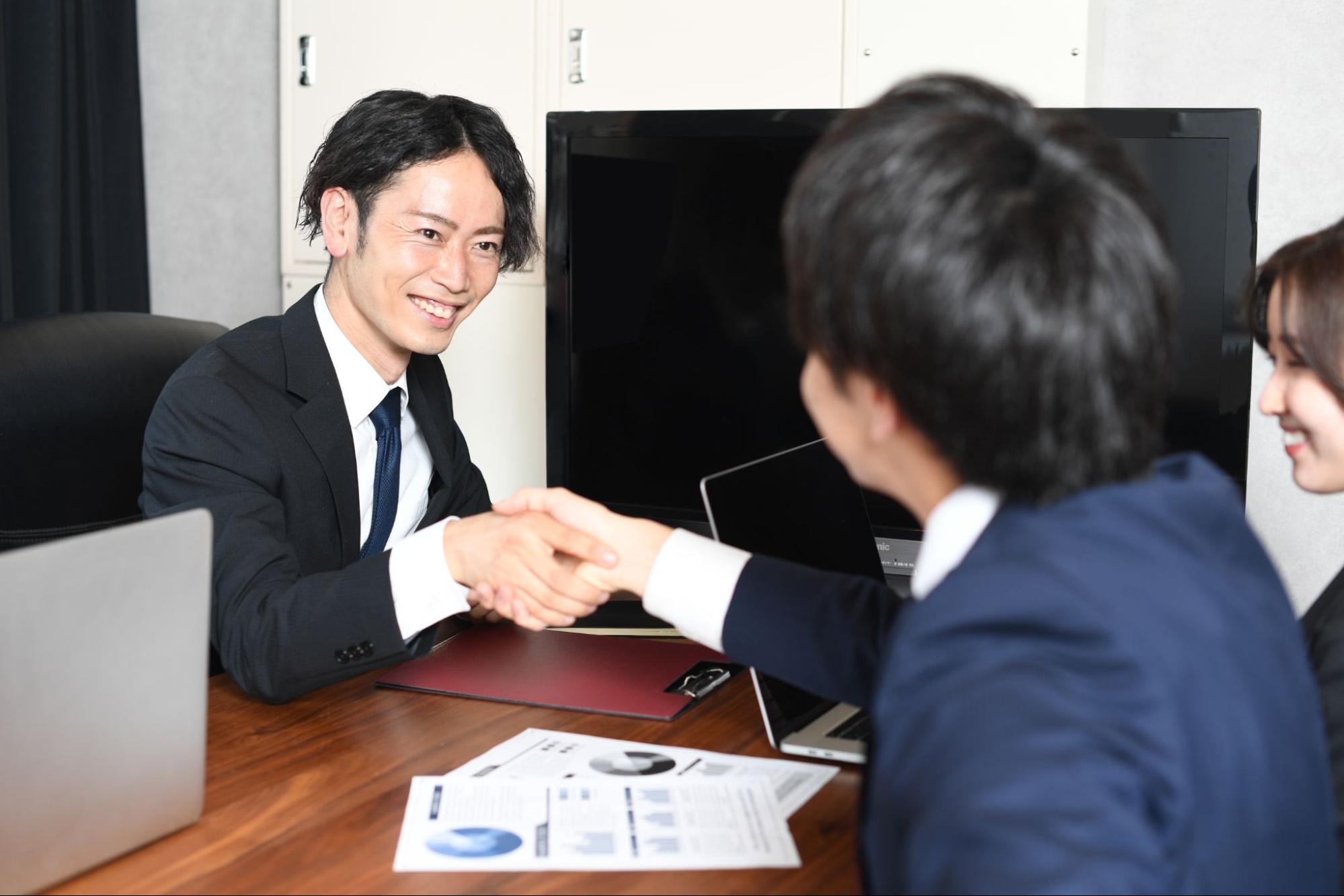 握手をするビジネスマンの男性達