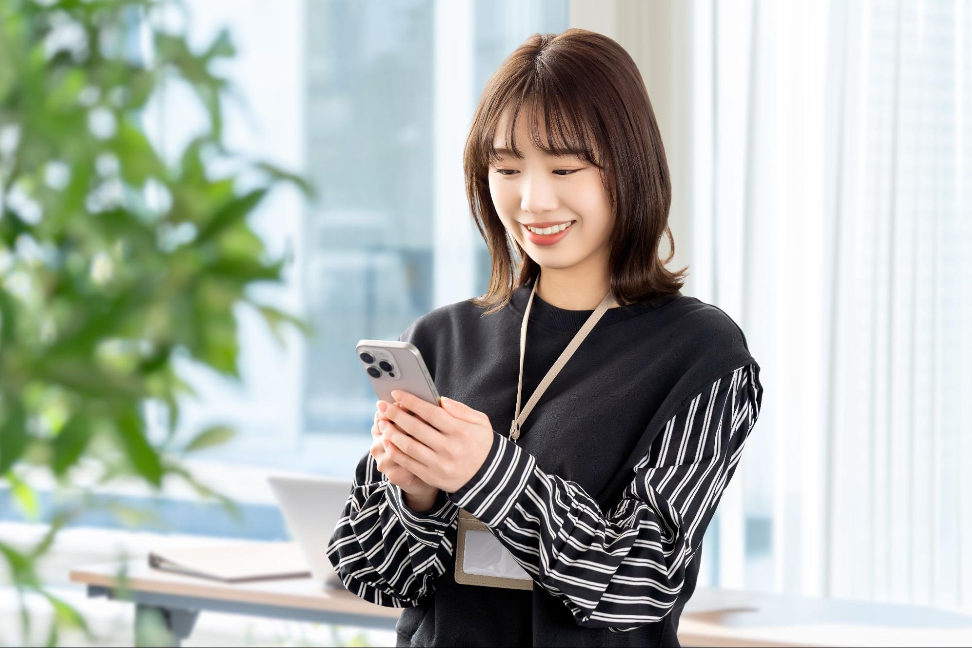 スマホを使う笑顔の女性