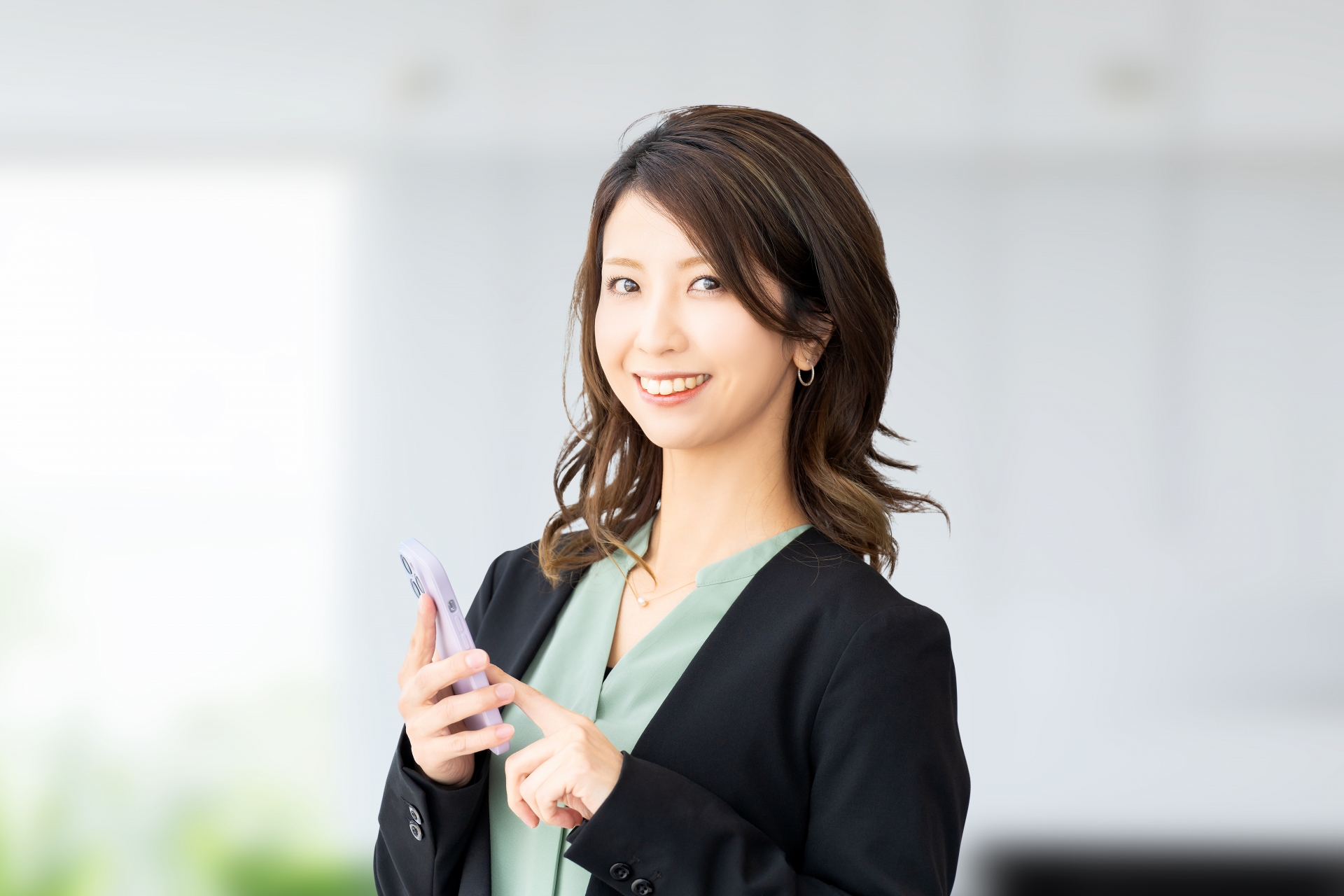 スマホを持つ笑顔のビジネスウーマン
