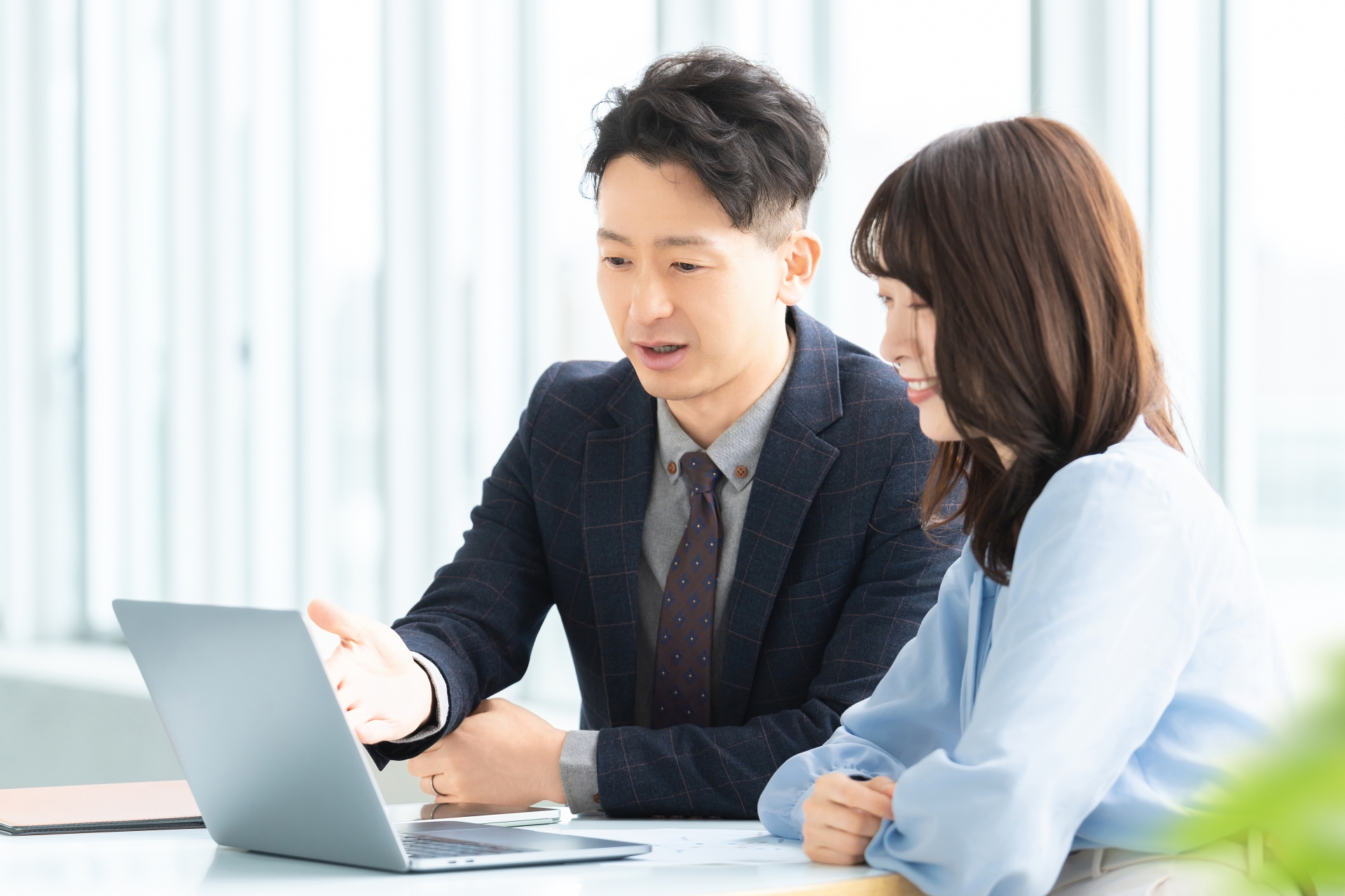 打ち合わせをする男女2人のビジネスマン