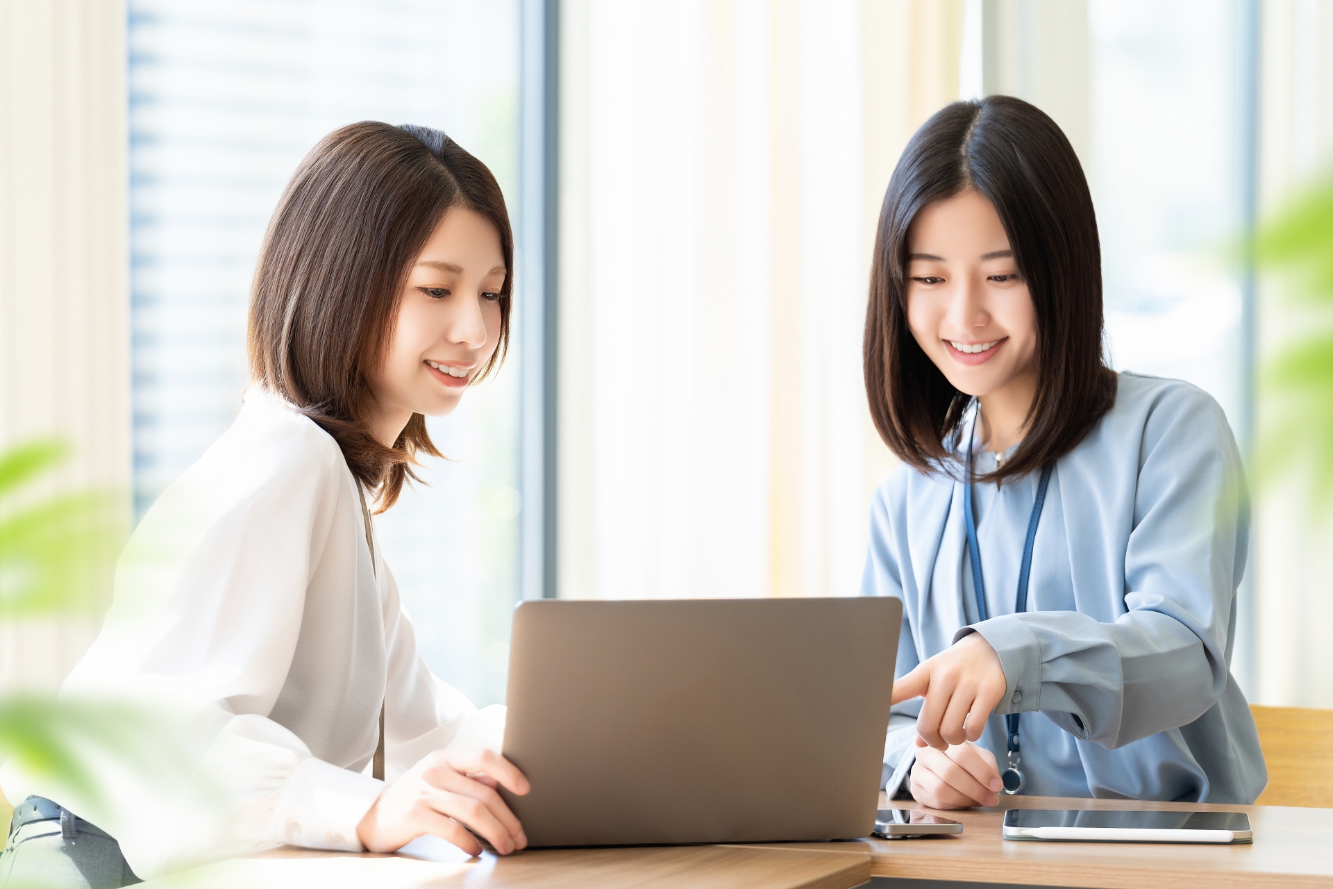 パソコンをのぞき込む二人の女性
