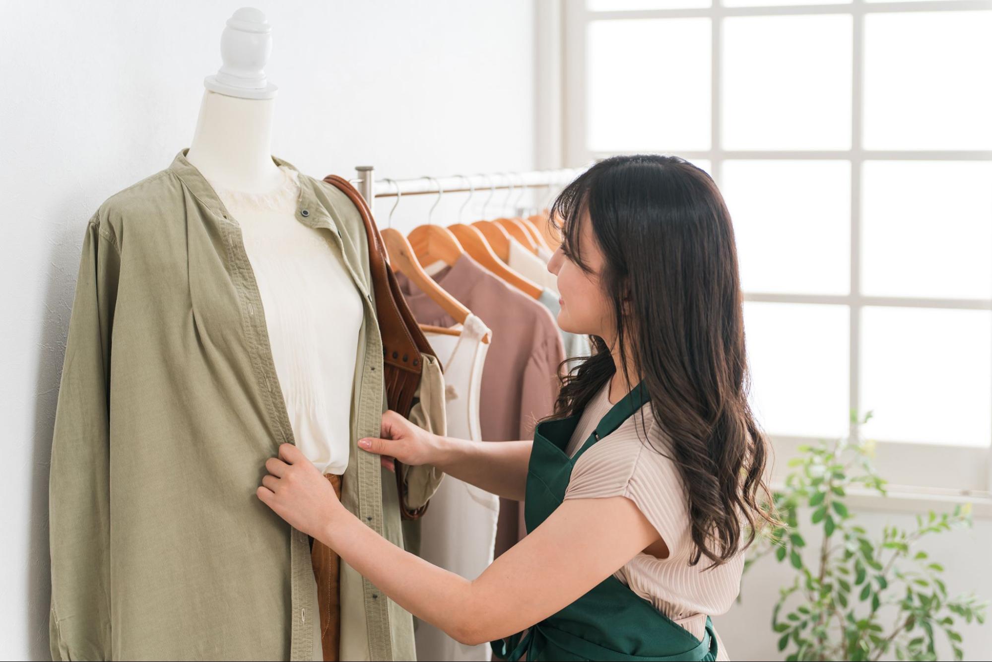 マネキンに服を着せる女性