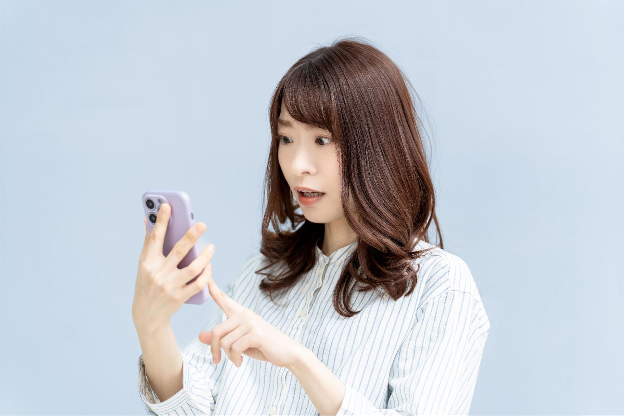 画面を見て驚く女性