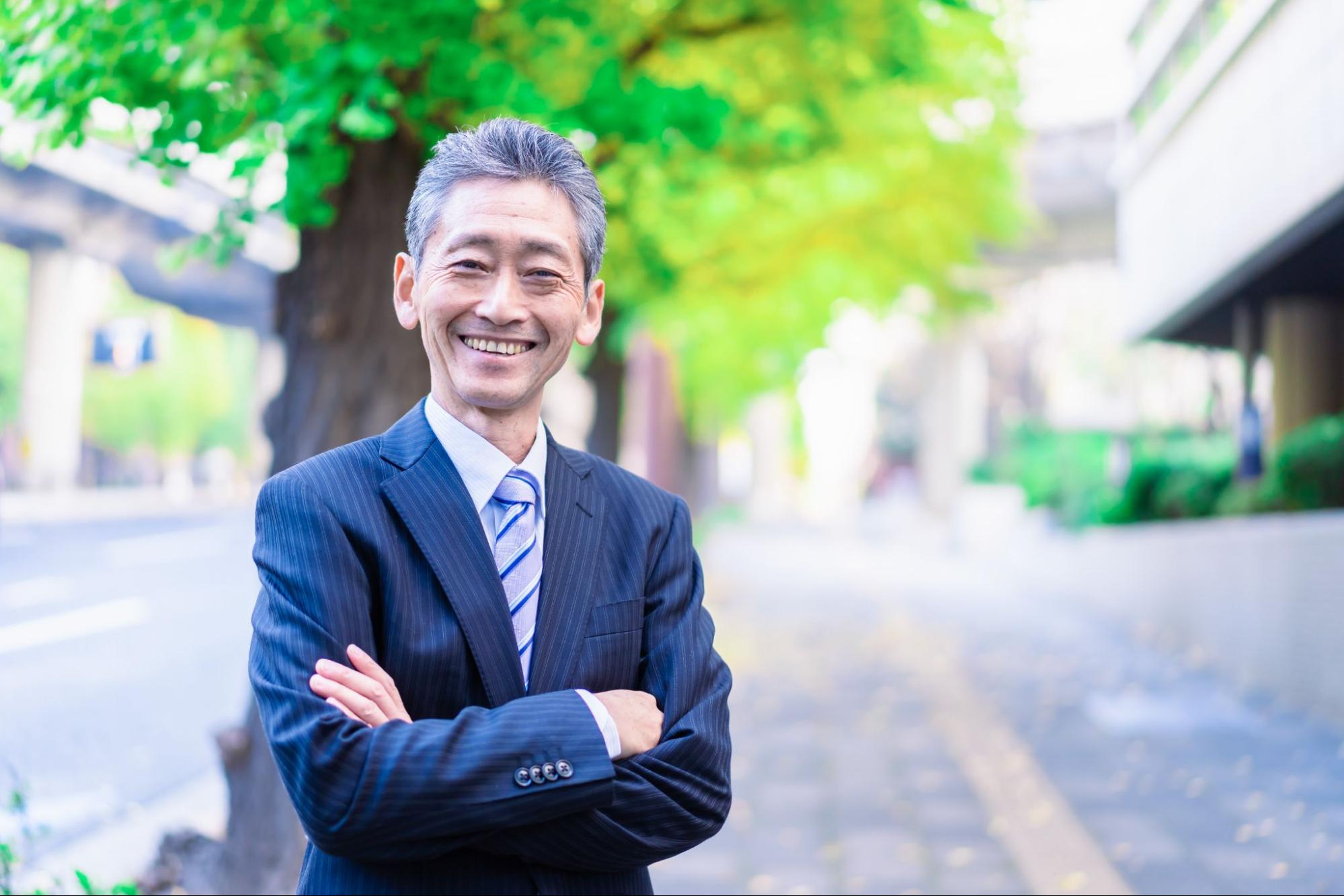 外で腕を組むビジネスマン