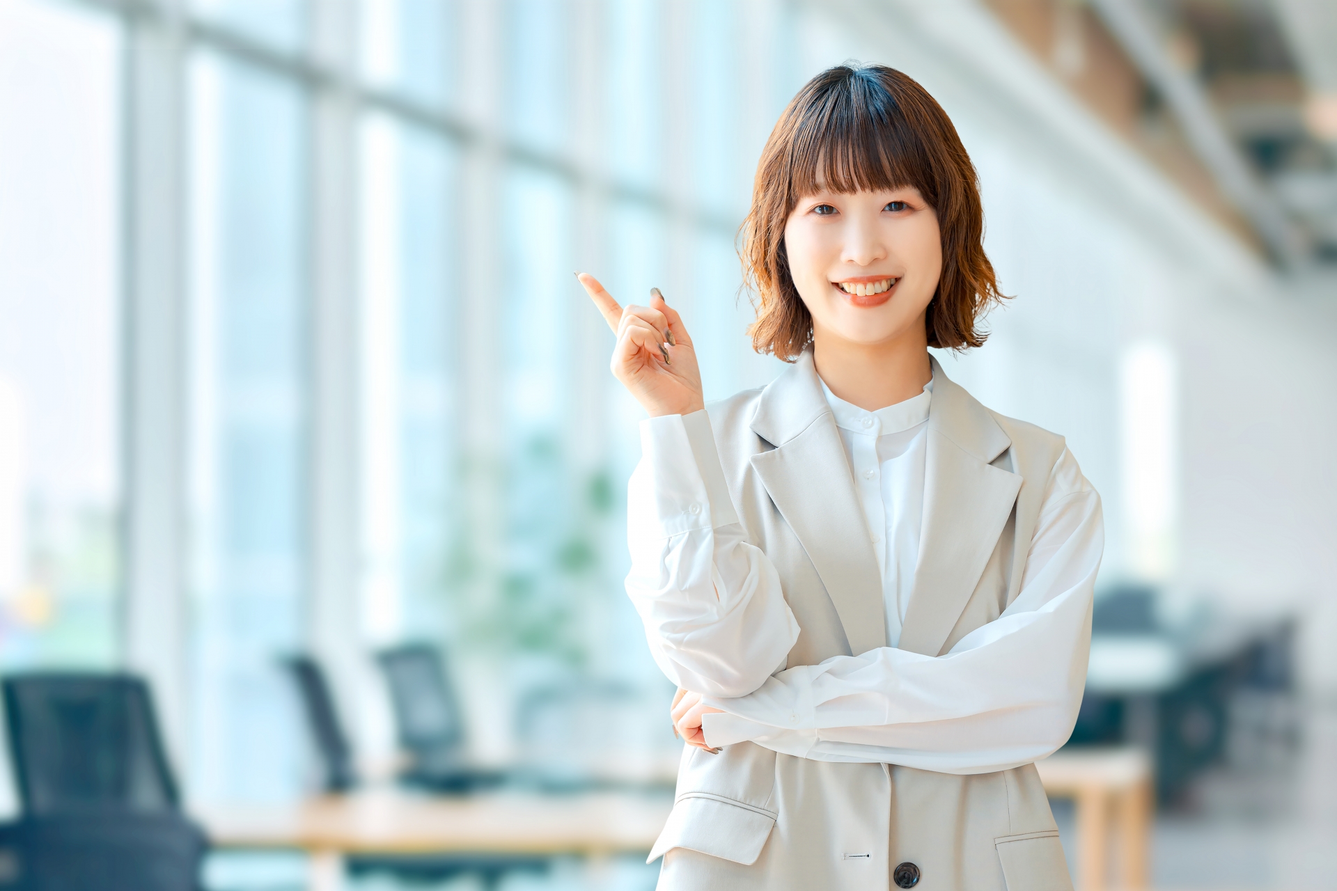 人差し指を立てて案内する笑顔の女性