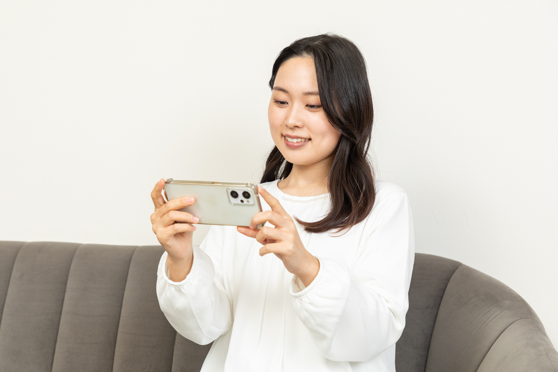 リビングで動画を見るアジア人女性