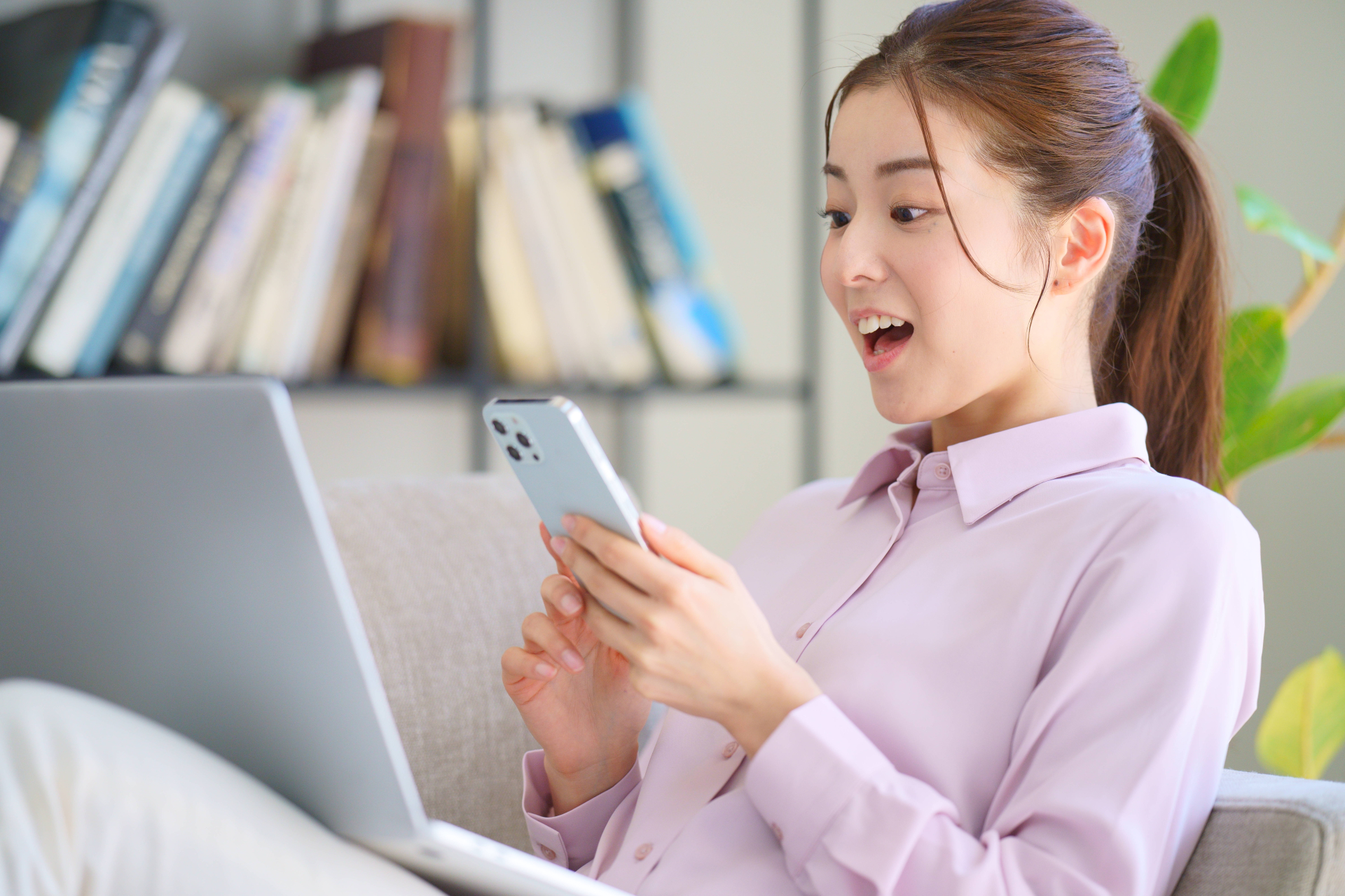 スマートフォンを見て驚いている女性