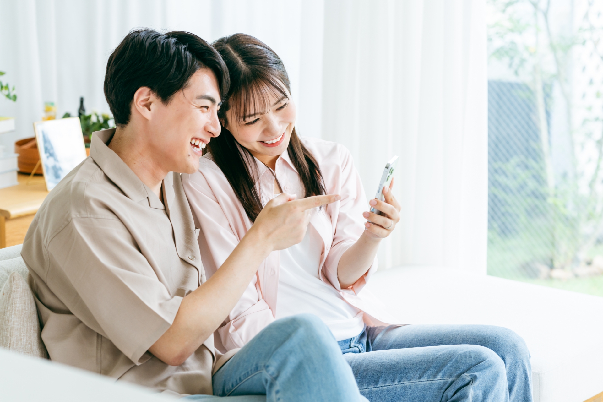 リビングでスマホを見るカップル