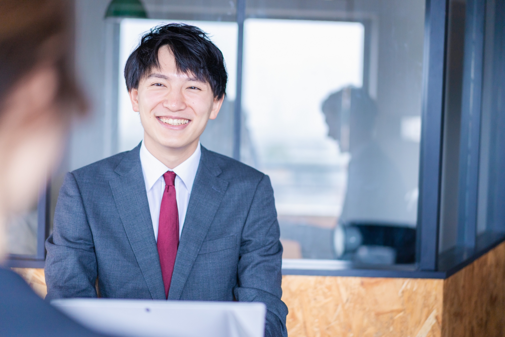 会議で発言をする若いビジネスマン