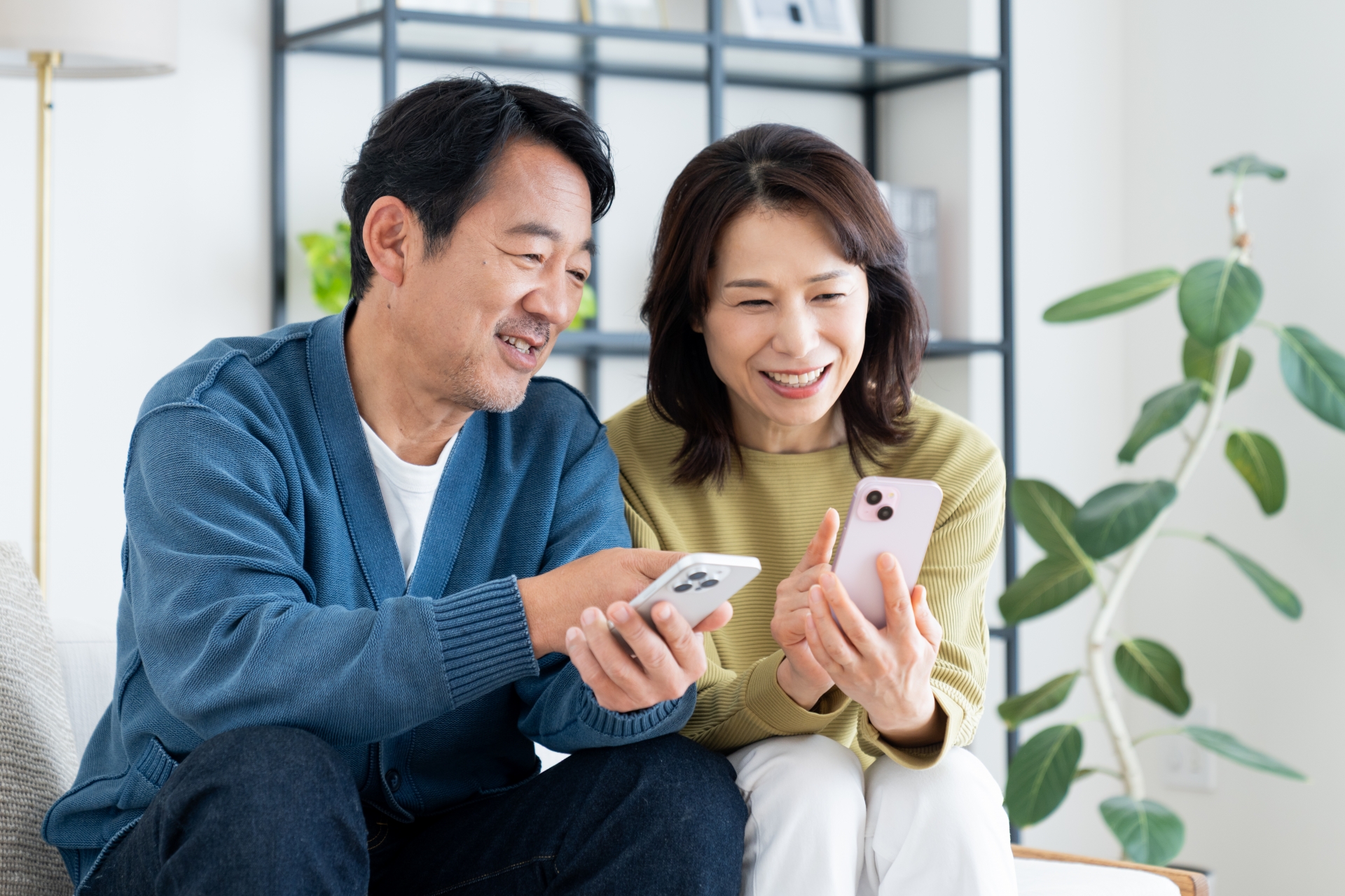 リビングでスマホを見るミドルの夫婦
