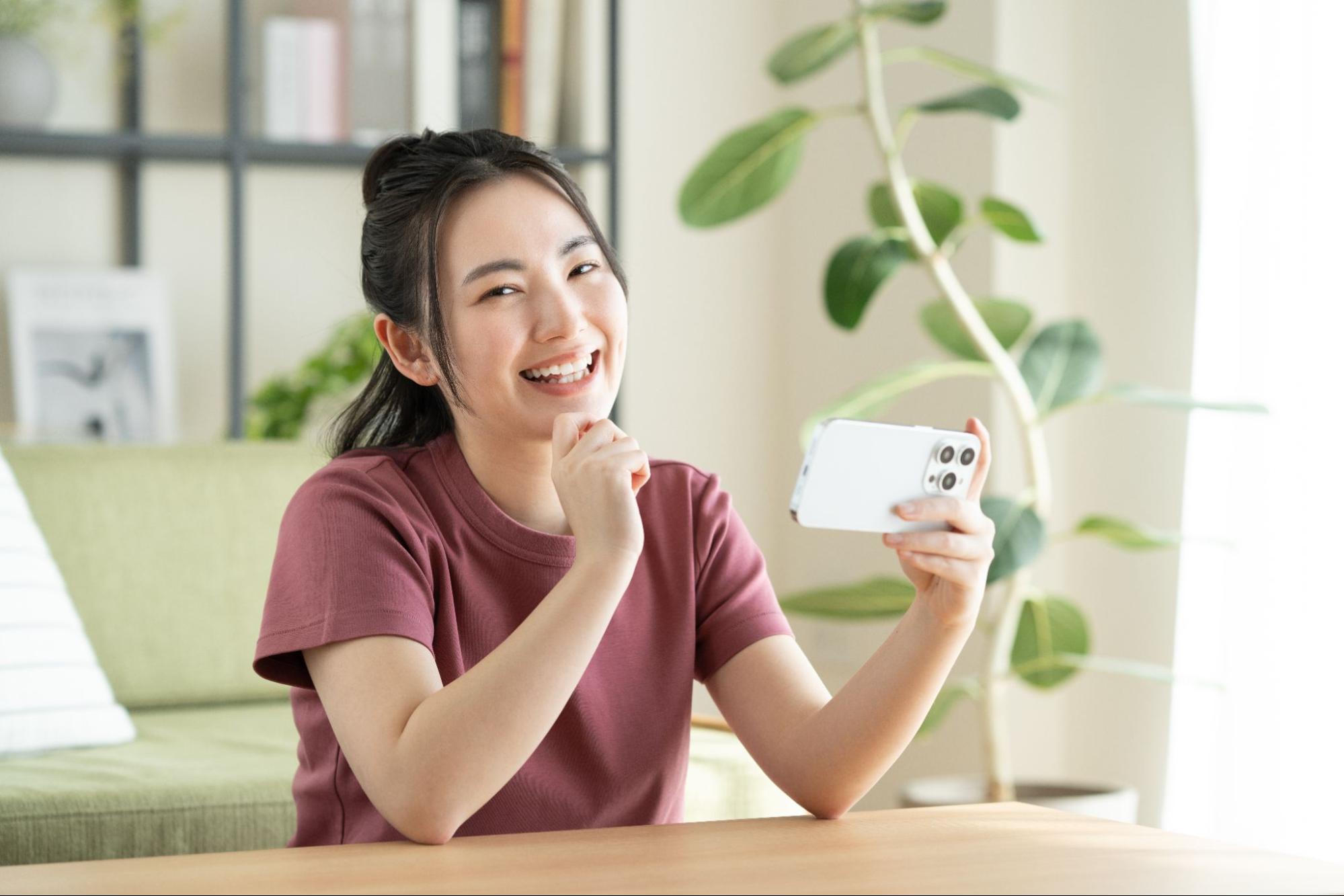 リビングでスマホを見る若い女性