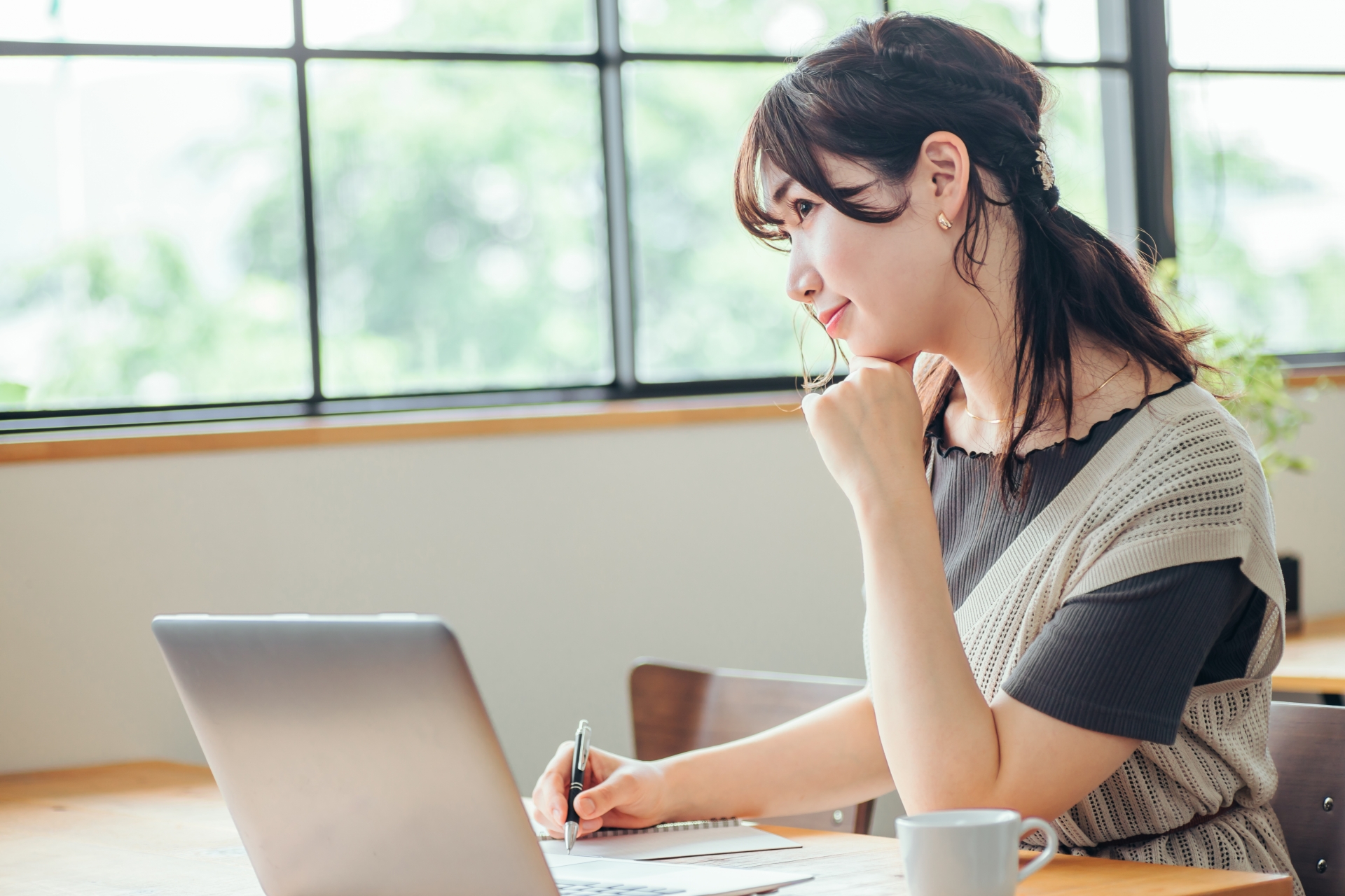 おしゃれ空間で勉強する女性（笑顔）