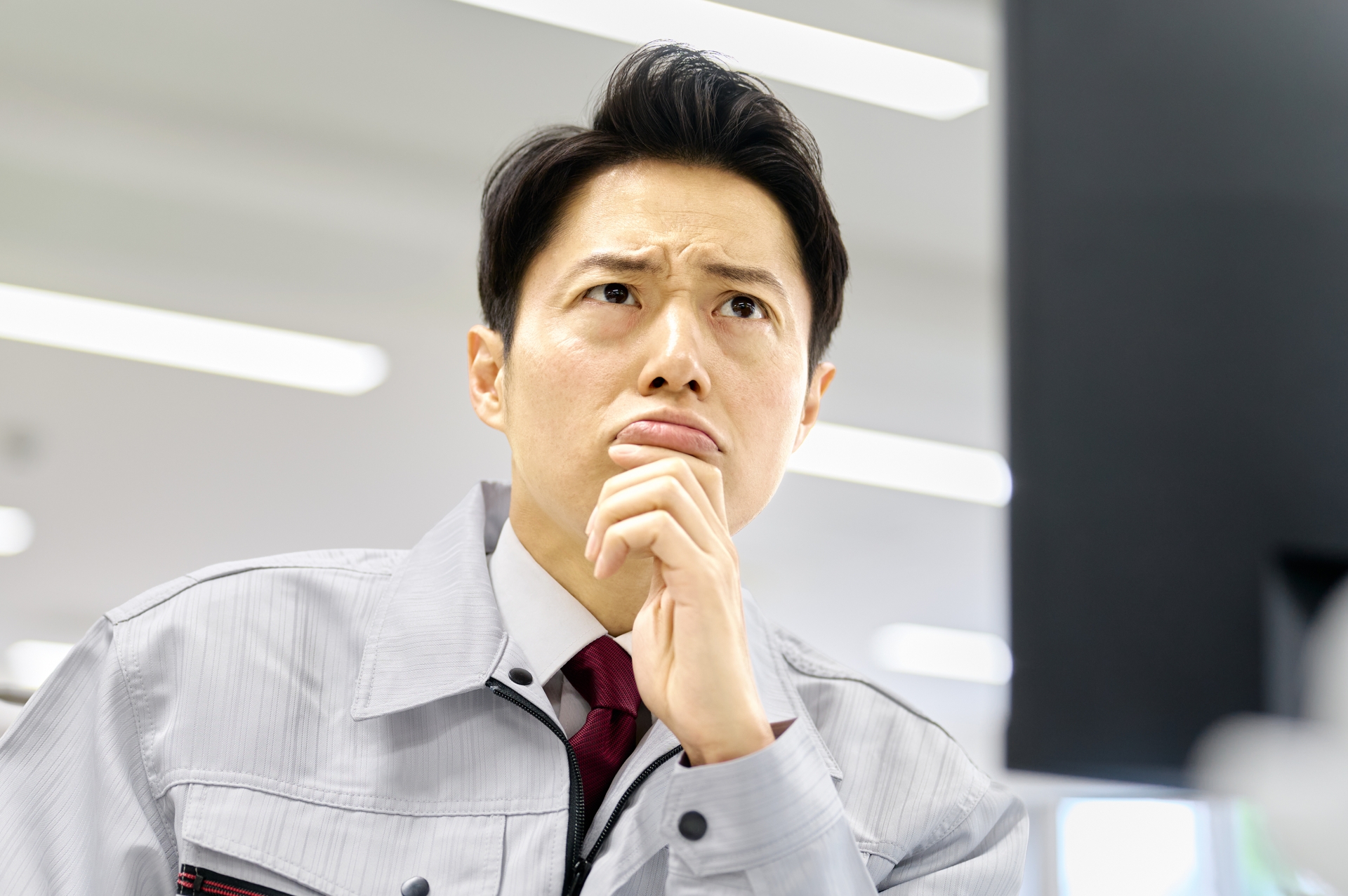 困った顔でパソコンを見る作業員