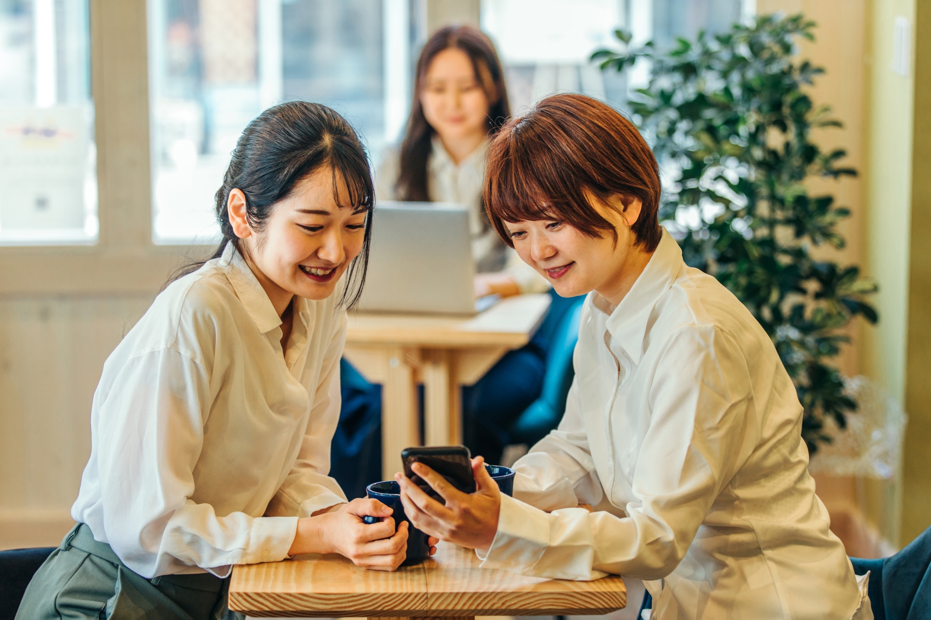 カフェでスマホを見るビジネスウーマン