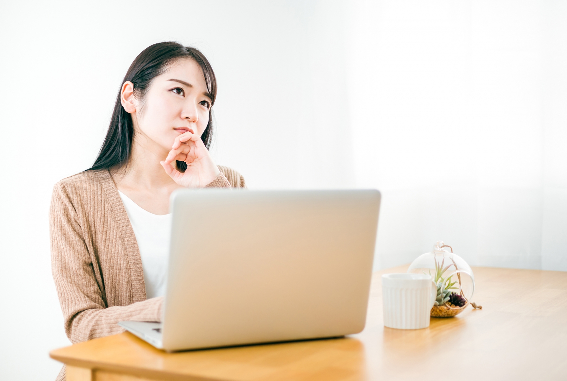 パソコンを使って考える女性