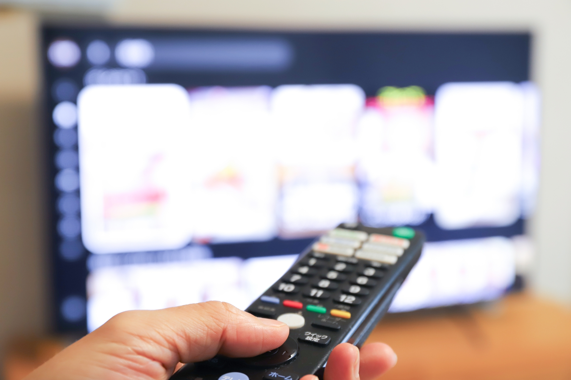 リモコンでテレビをつける手元