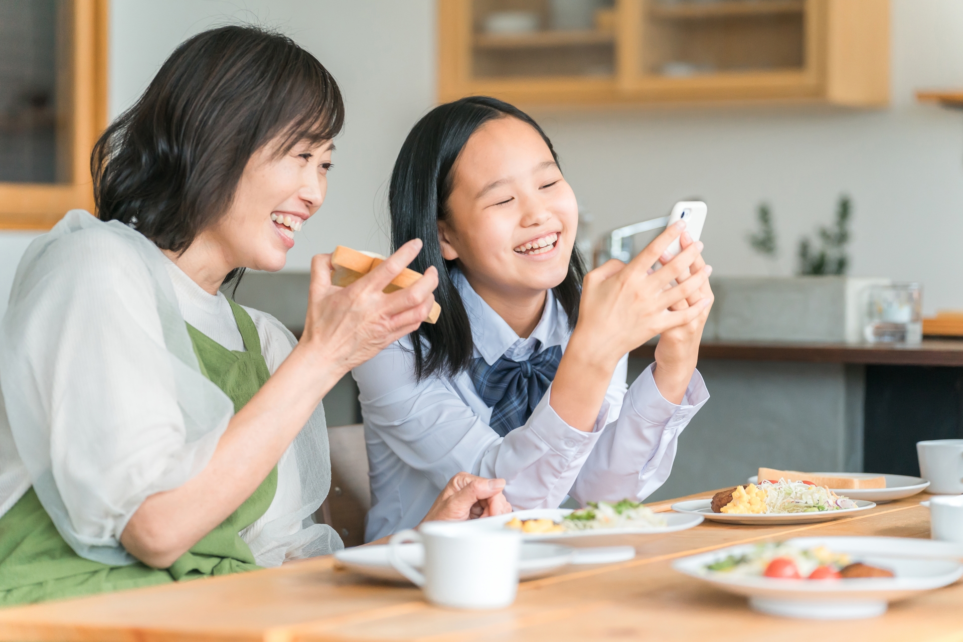 ママと一緒にスマホを見る子供・中学生
