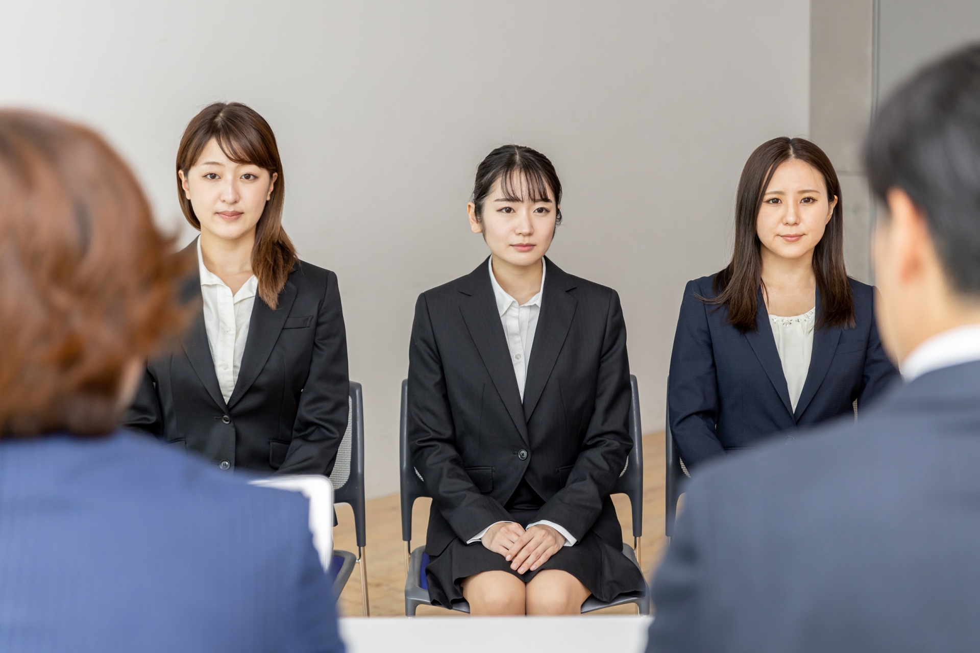 集団面接で面接官の話を聞く就活生（真剣）