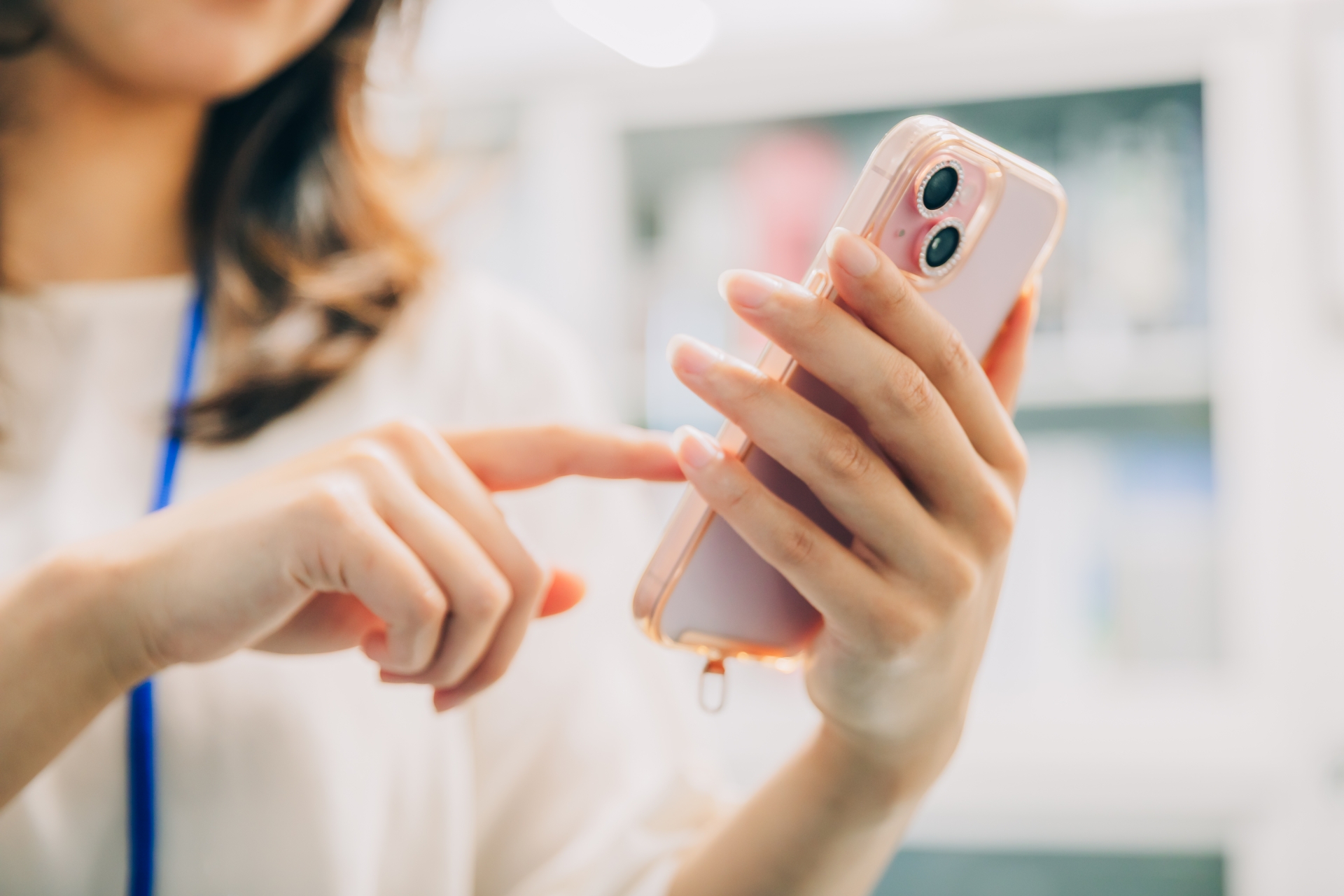 スマホを操作するビジネスウーマンの手元