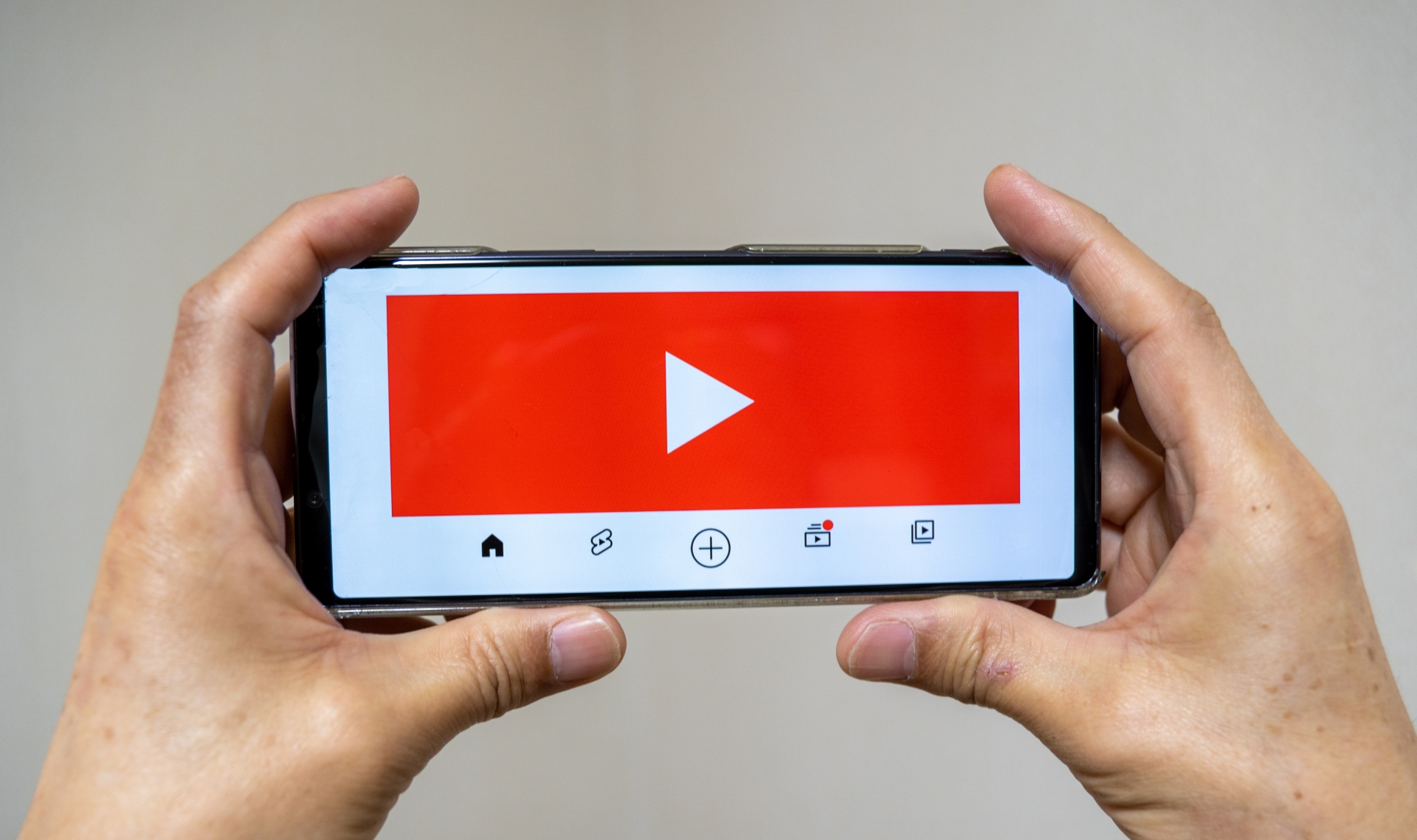 両手でスマホを持って動画を視聴
