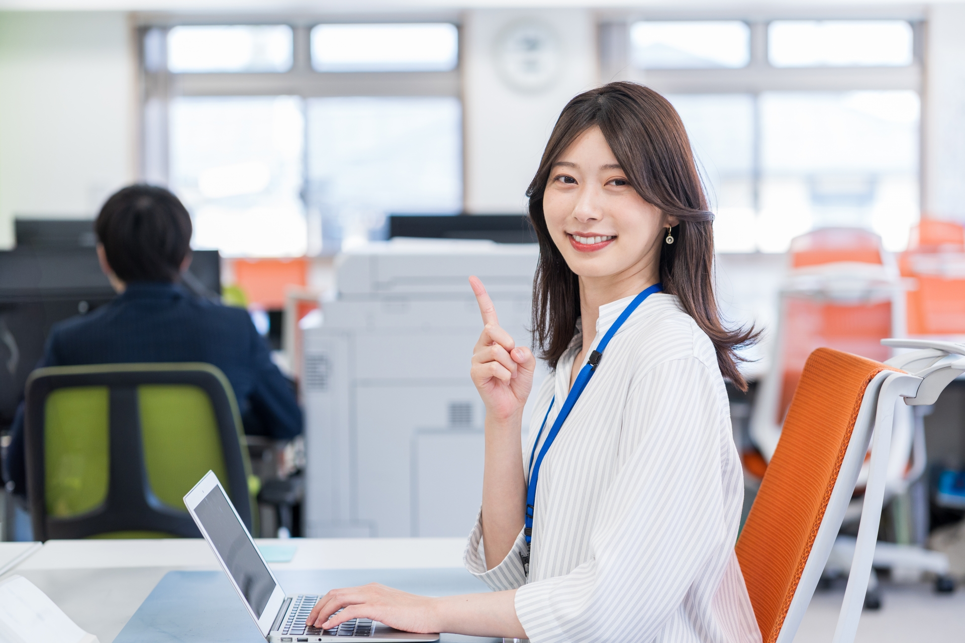 オフィスで働く人差し指を立てている若い女性