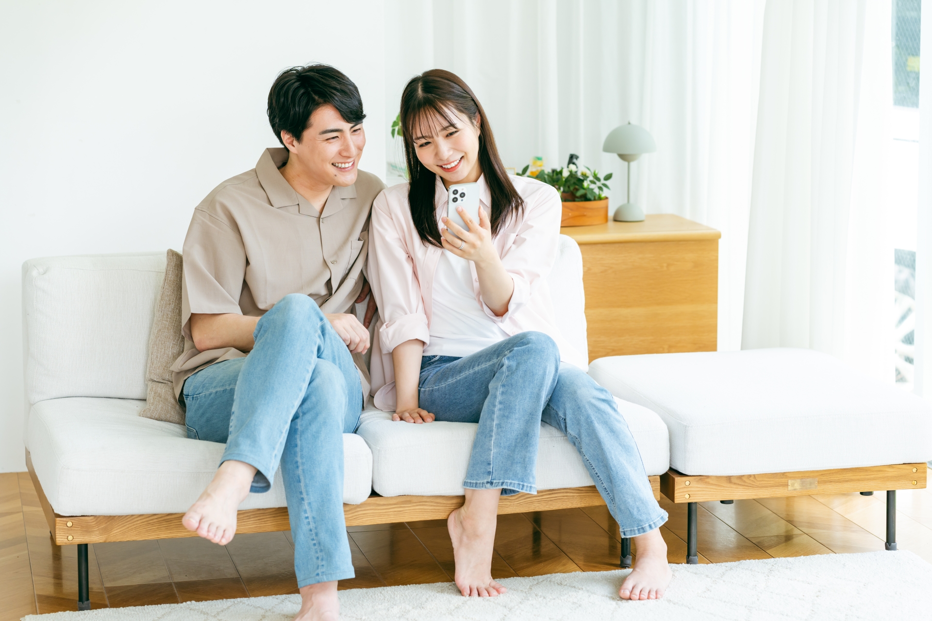 リビングでスマホを見る男女