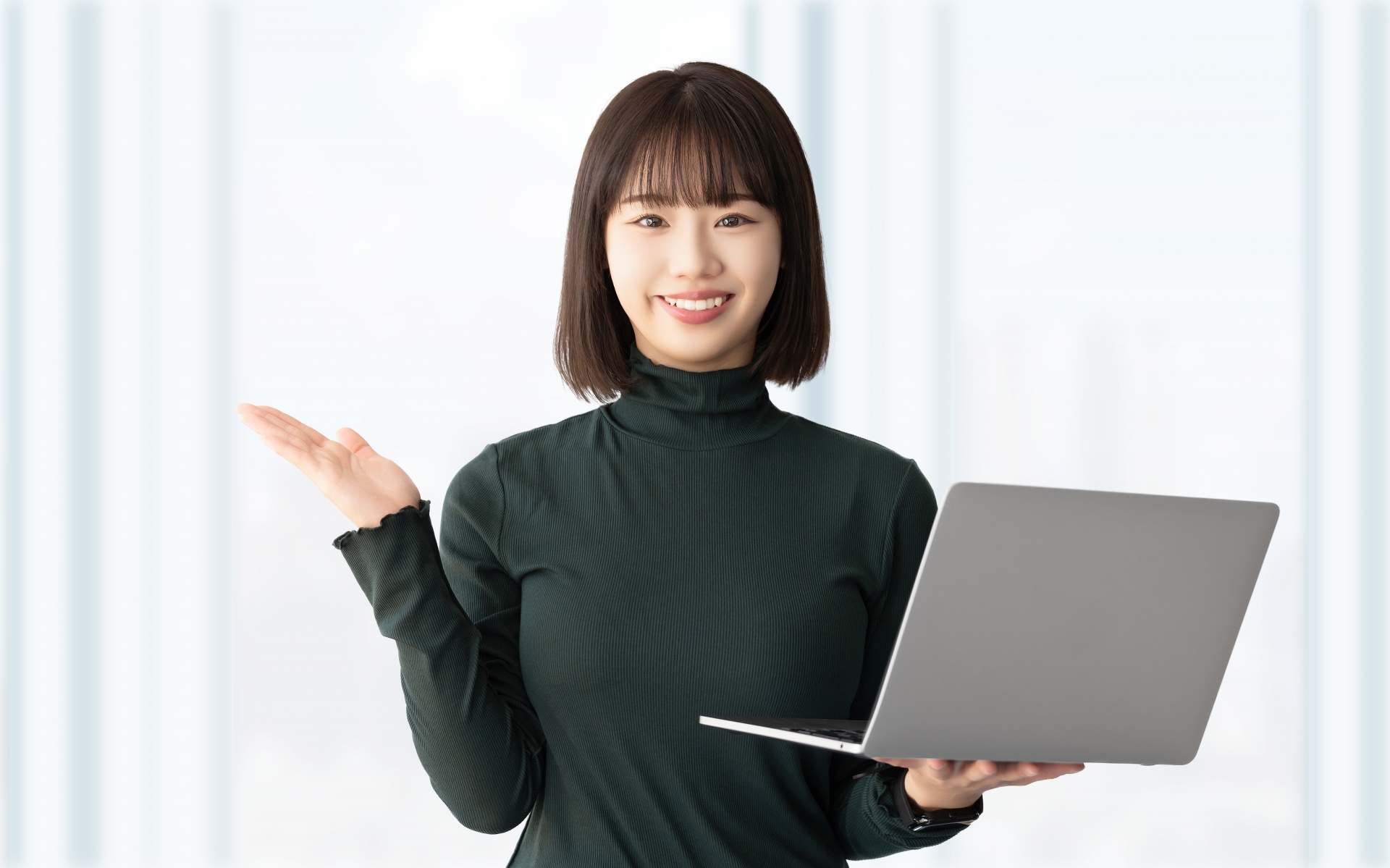パソコンを持って案内をする笑顔の女性