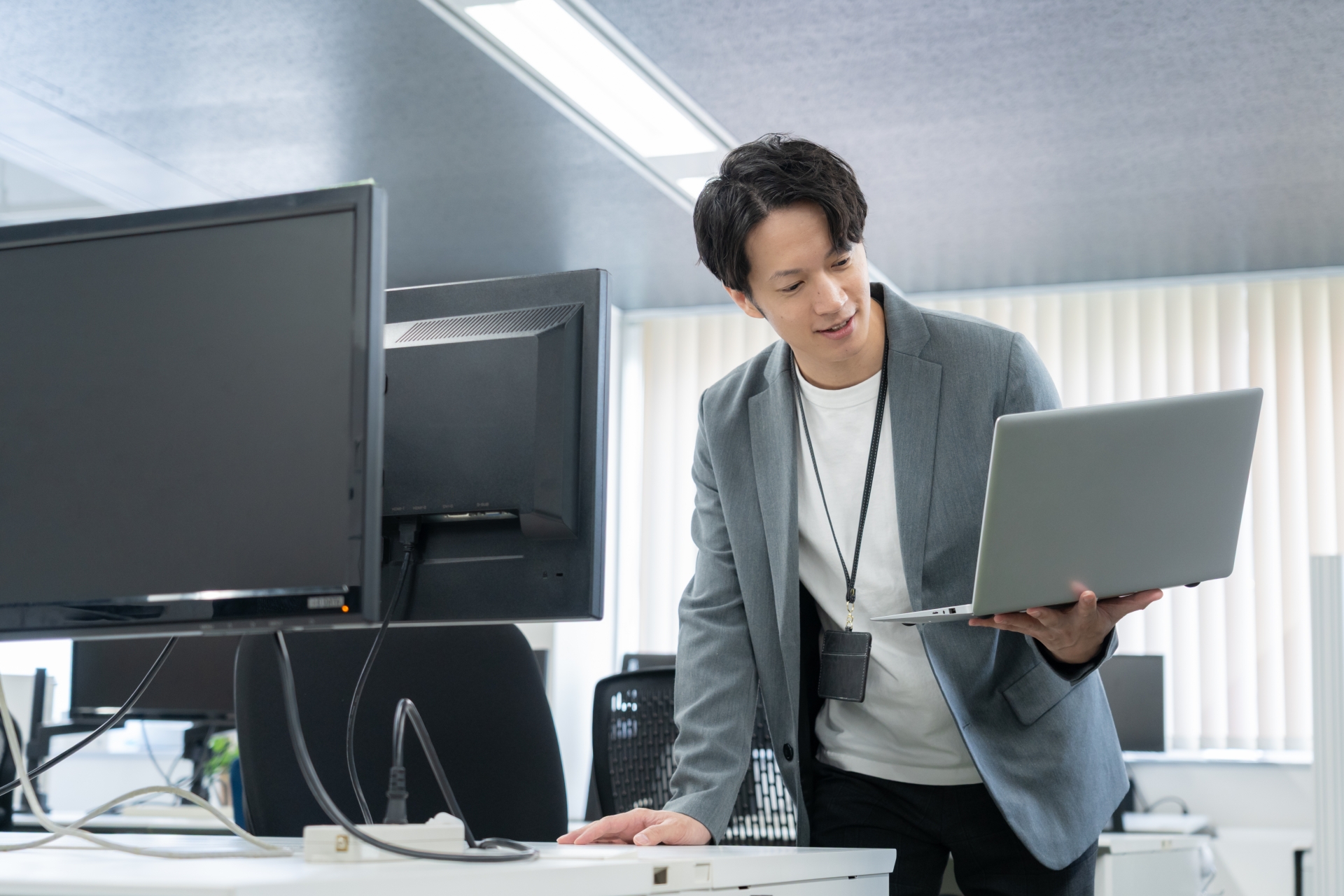 オフィスでパソコンを持っている若い男性