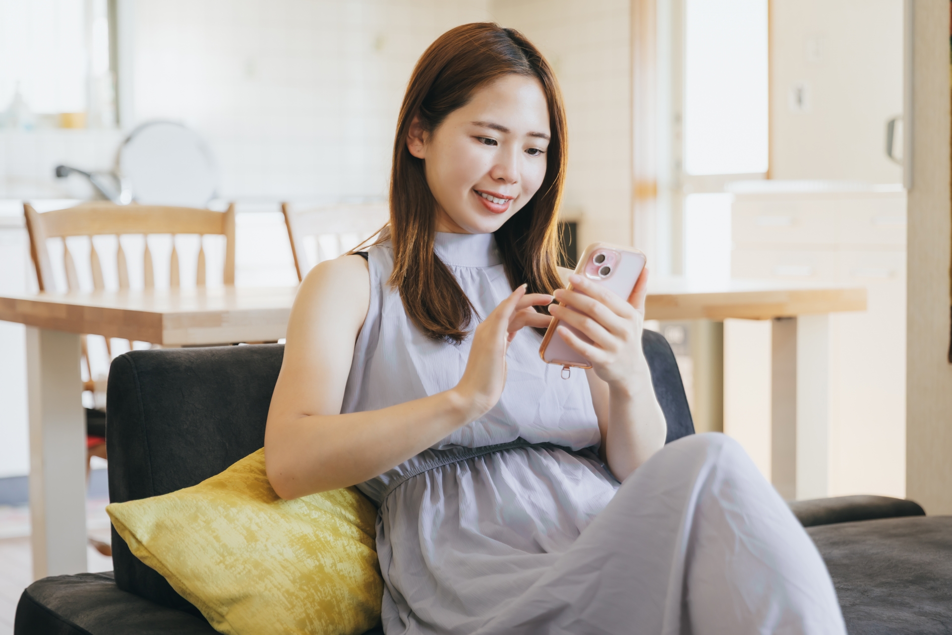 リビングでスマホを使う女性