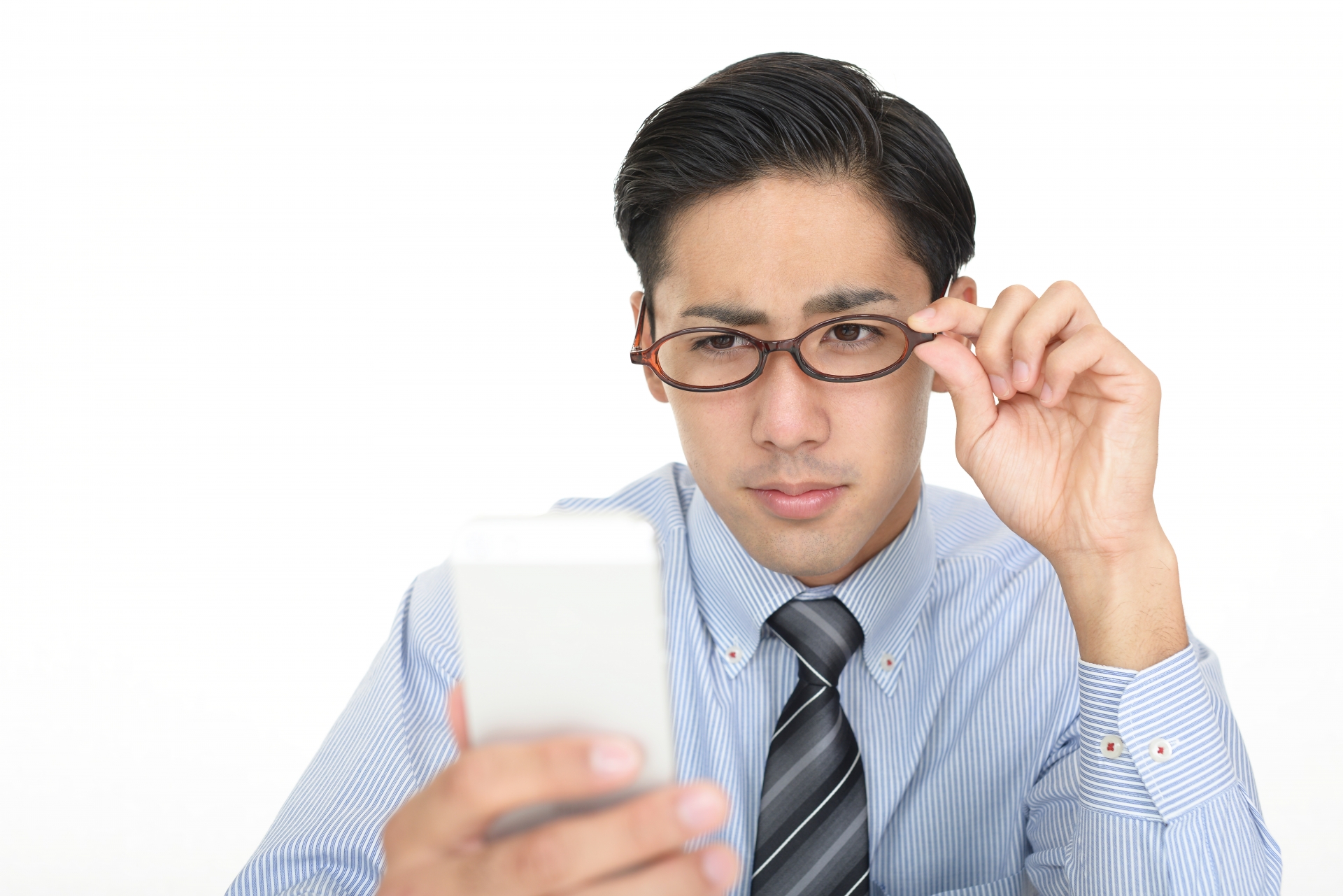 スマートフォンを持って悩む男性